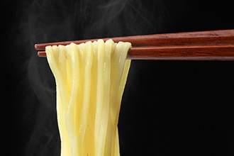 麺を箸で持ち上げている写真