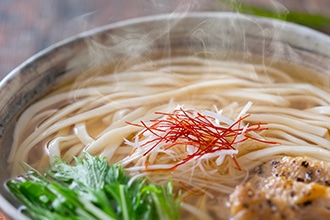 器に盛った湯気が出ているうどんの写真