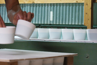 大量の器を机に並べていく様子の写真