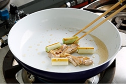 ぶつ切りにした長ネギを炒めている写真