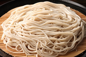 丸い竹ざるの上に盛った薫そばの写真