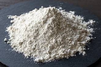 平たい器の上で山にしているそば粉の写真