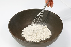 そば粉を泡だて器で軽く混ぜている写真