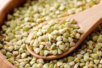 そばの実を木のスプーンですくっているアップの写真