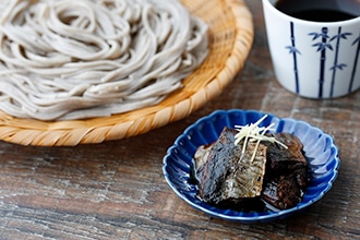 ざるそばと小皿に乗せたにしんのうま煮が一緒に映った写真