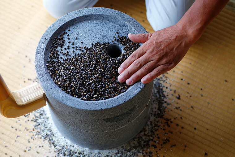 石臼でそばの実を挽いている様子